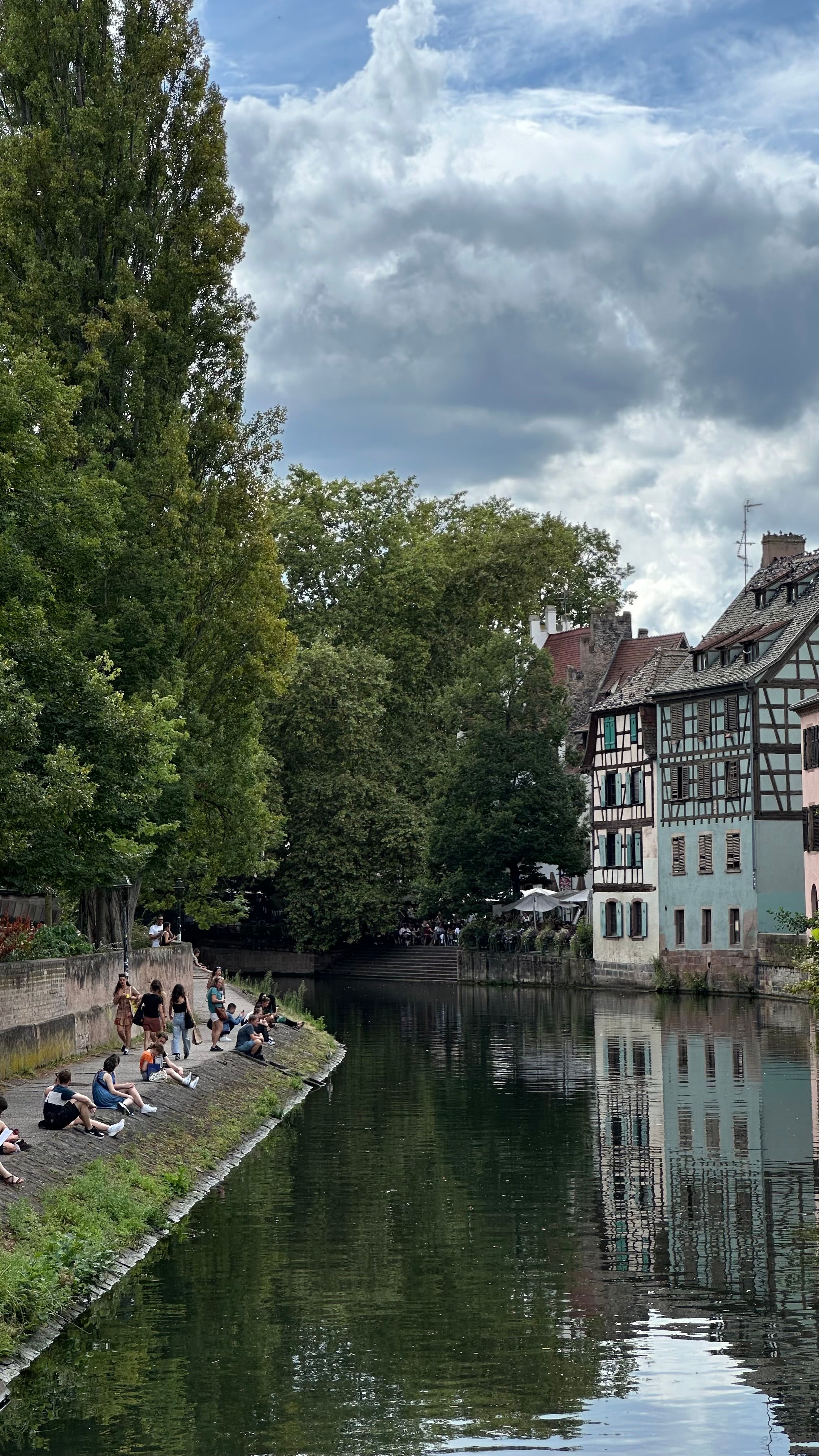 Berge bordée de maisons anciennes à colombages et de végétation, en périphérie de Strasbourg.