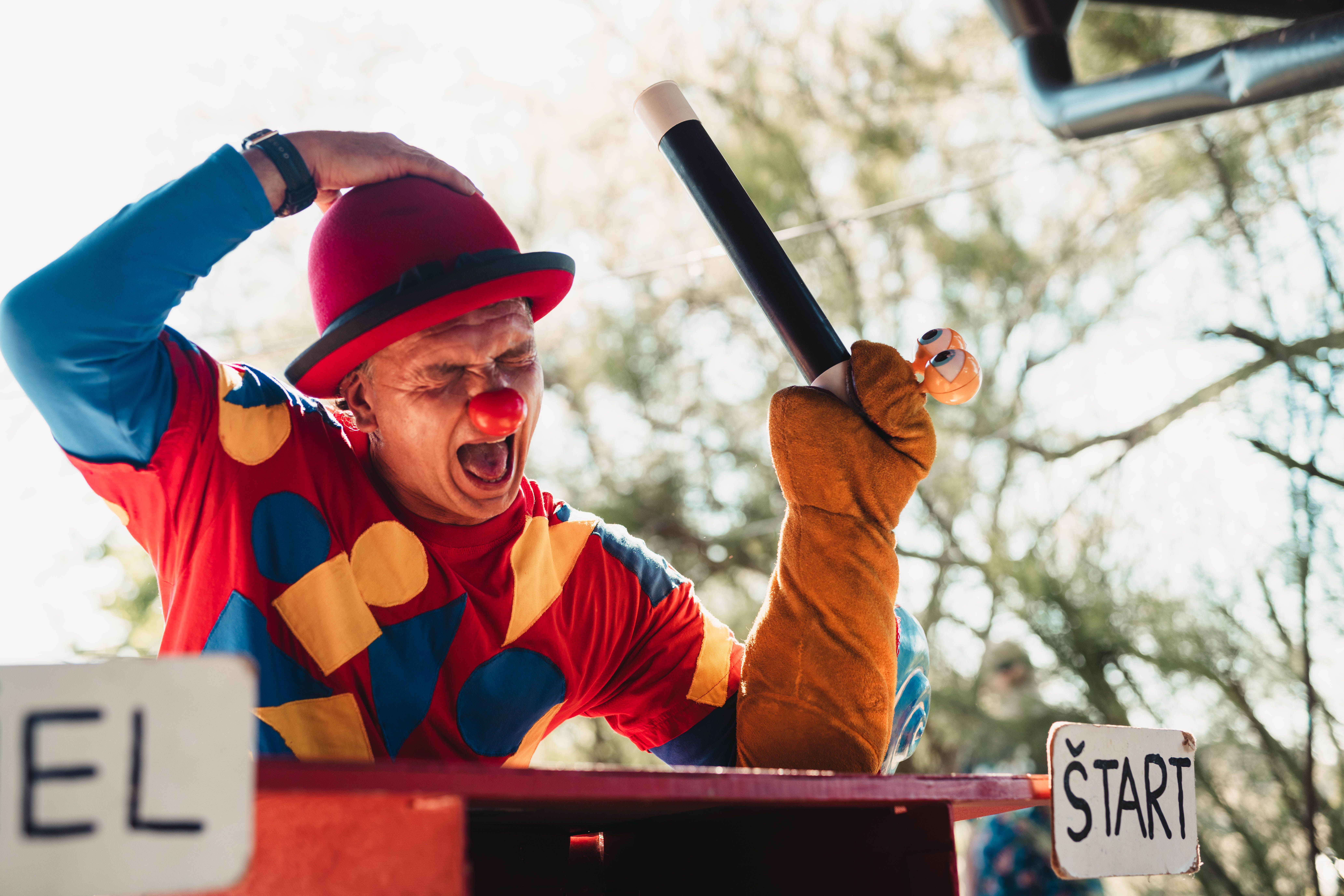 Cheerful Clown Performing Magic Trick Outdoors · Free Stock Photo