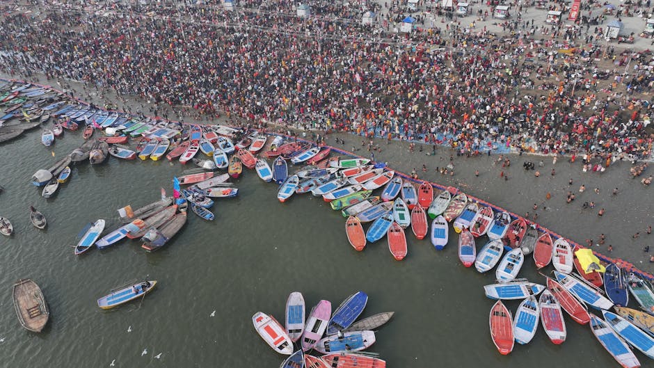 Aerial shot showcasing the bustling crowd and colorful boats at Kumbh Mela in Prayagraj.