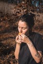 秋天，一名女子在户外品尝着一块橙子，周围是自然环境