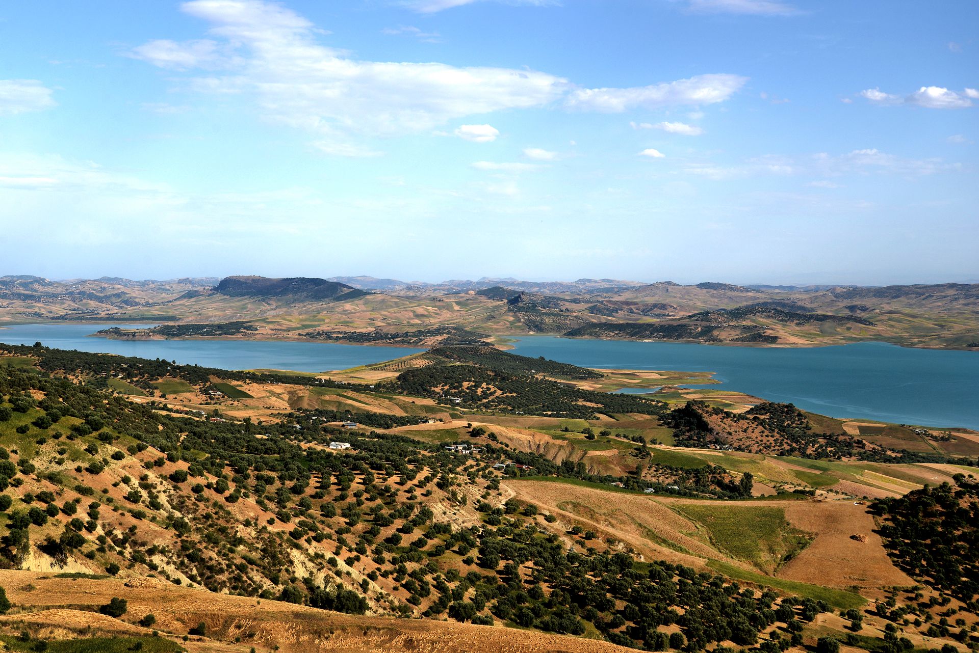 Scenic rural landscape in Taounate, Morocco with rolling hills and a lake.