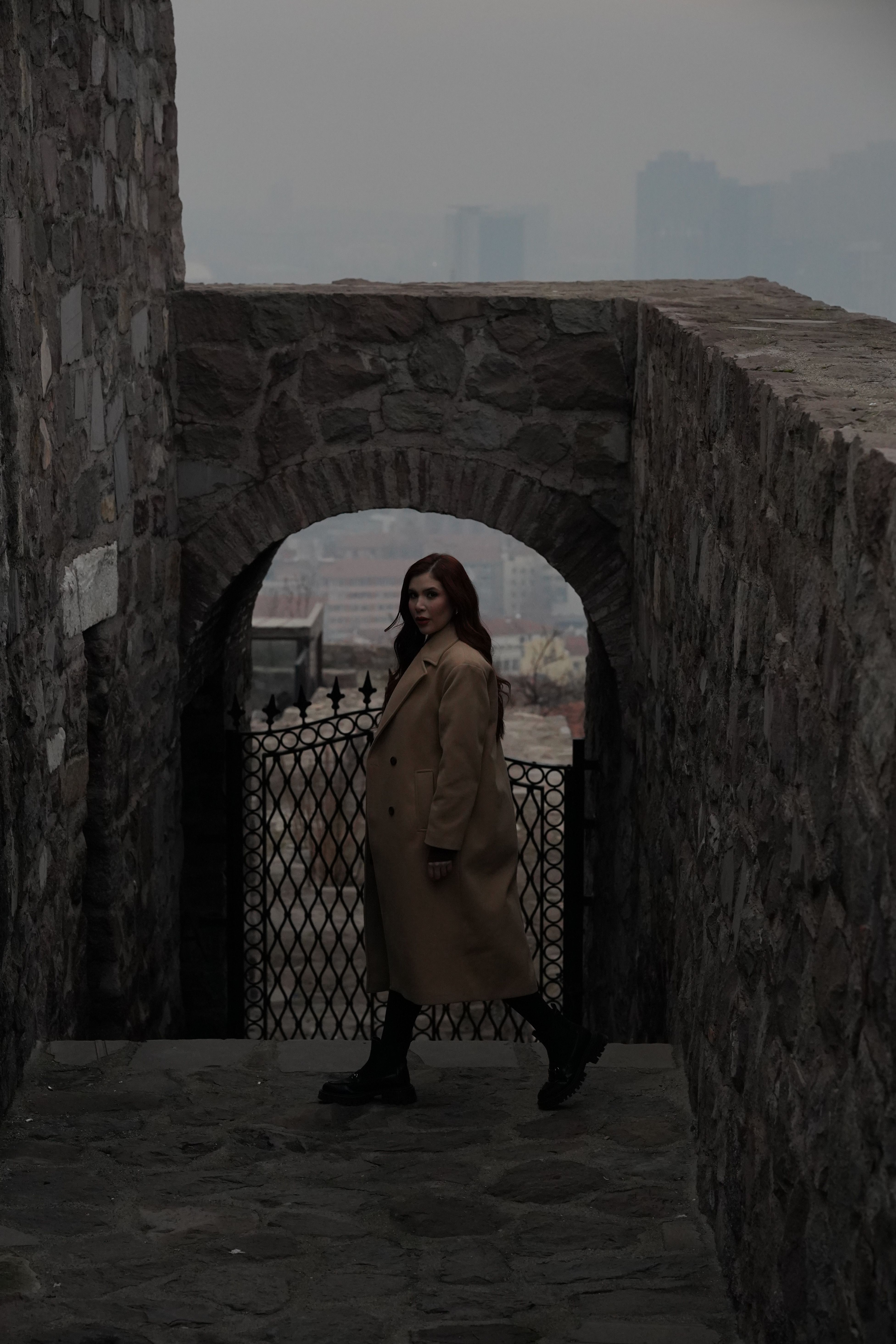 Woman Walking Through Stone Archway · Free Stock Photo