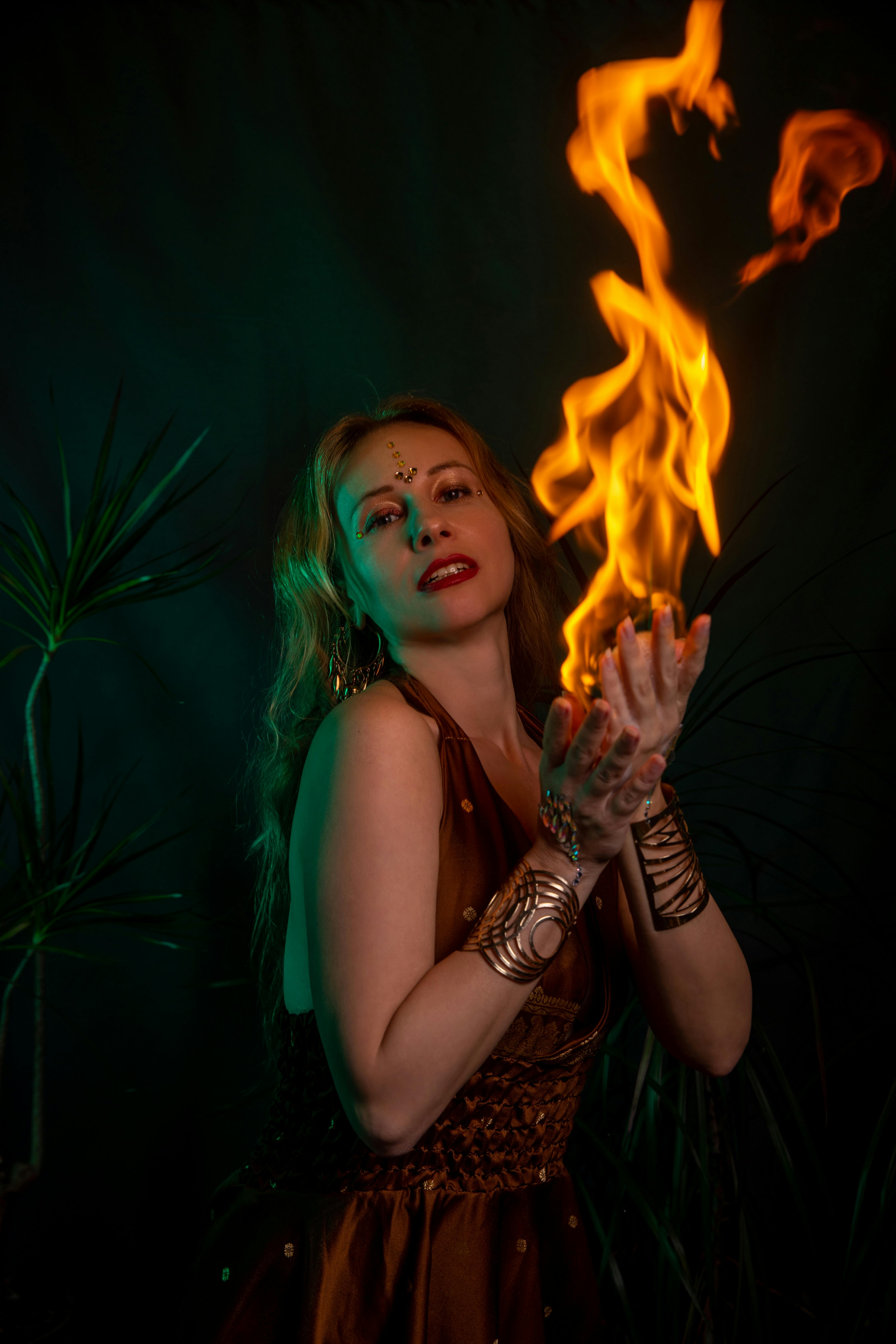 Ücretsiz Mistik bir kadın büyüleyici bir ateş dansı sergiliyor ve izleyicileri alevlerle büyülüyor. Stok Fotoğraflar