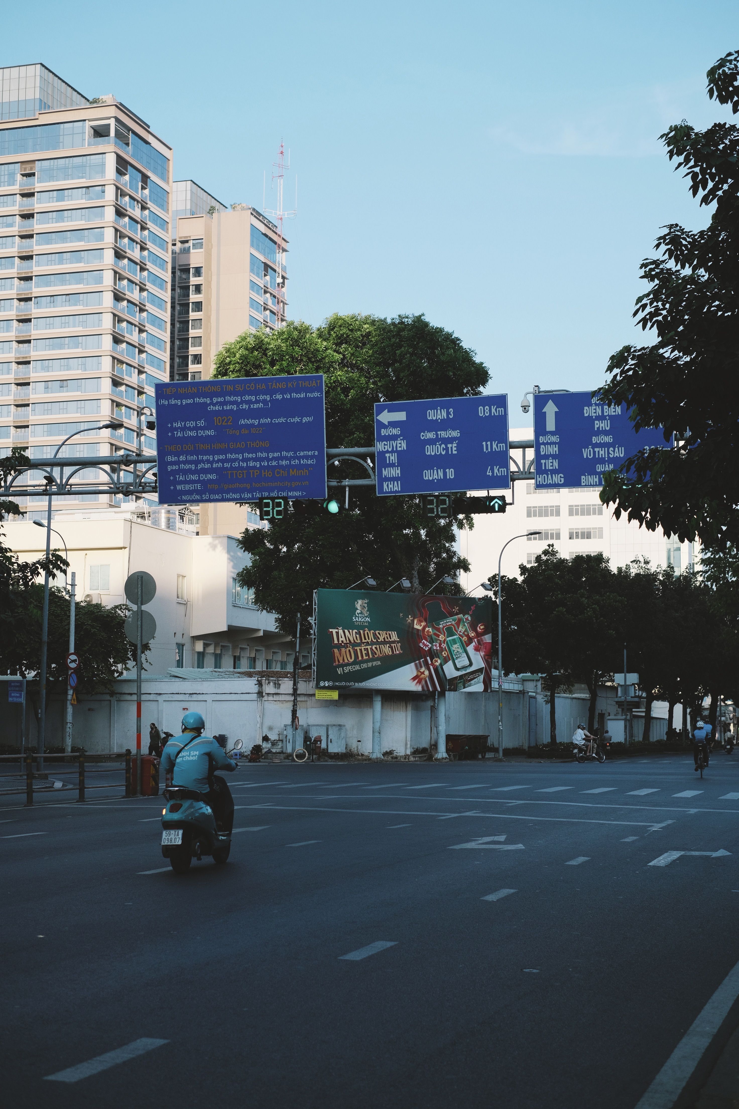 City street with scooter and traffic signs under clear blue sky.