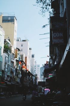Urban city street with buildings and signage, bustling daytime scene.