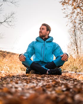 秋天，一名身穿蓝色夹克的男子在落叶铺满的小路上沉思