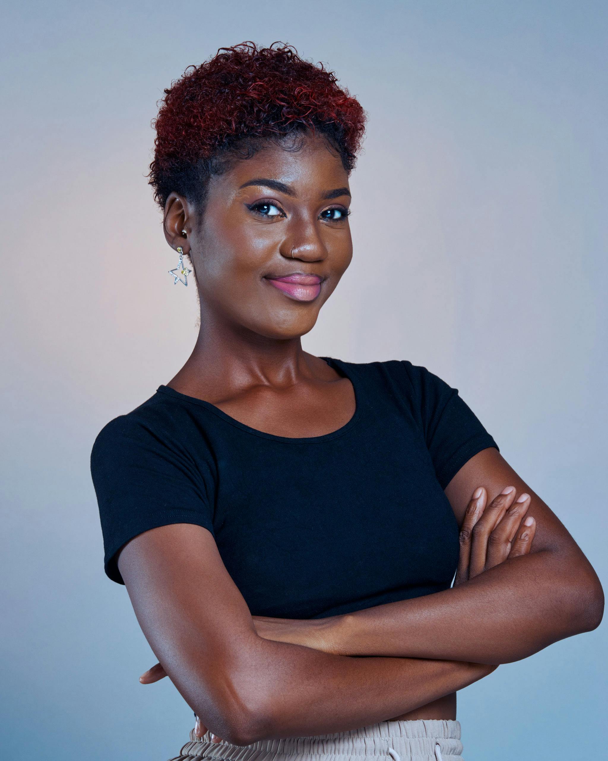 Portrait of a confident young woman with arms crossed, exuding poise and elegance.