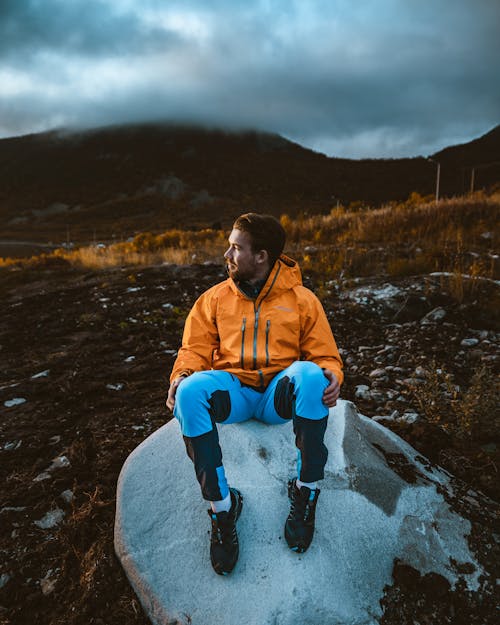 岩の上に座っている男の写真