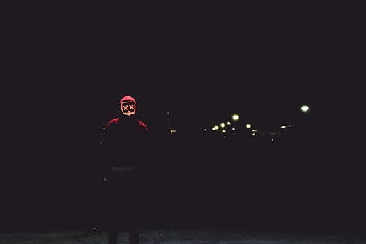 黑暗的街道上，一个戴着发光面具的人独自站立，散发着神秘与阴谋的气息