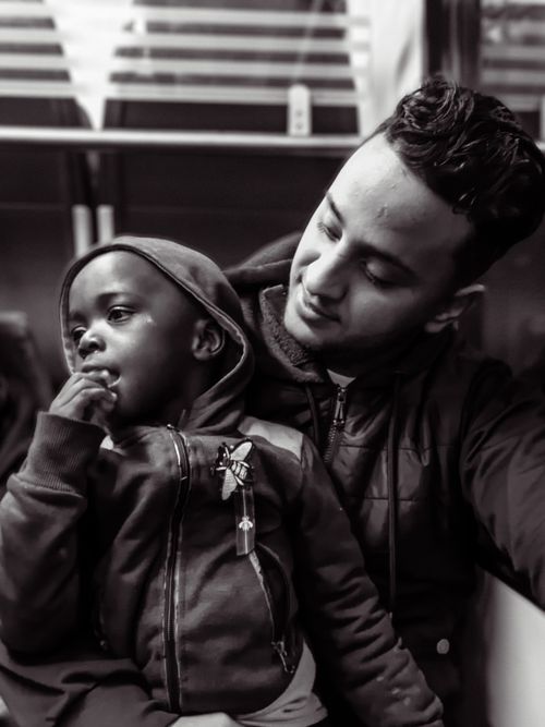 Free A heartwarming black and white portrait capturing a tender moment between two brothers in a subway. Stock Photo