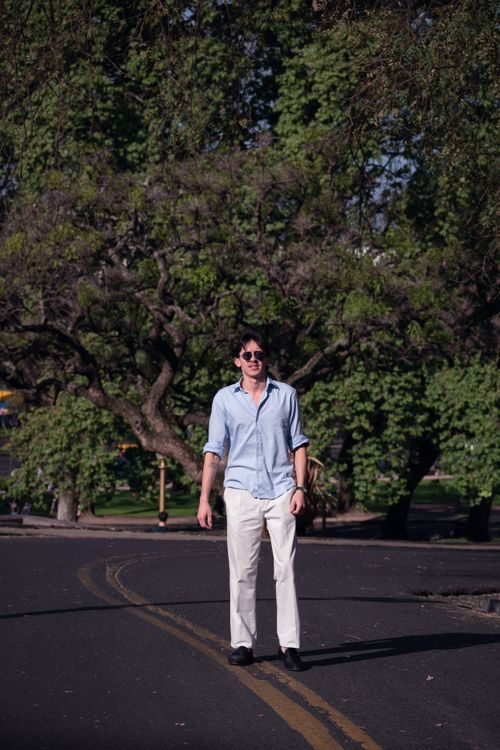 Free Chic portrait of a young man in sunglasses on a sunny day in Buenos Aires, surrounded by vibrant greenery. Stock Photo