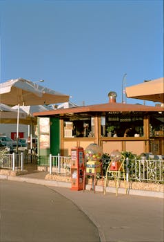 Charming retro snack bar with gumball machines and umbrellas on a sunny day.