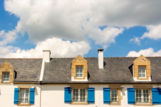 Picturesque rooftop with blue shutters against a vibrant sky, capturing architectural elegance.