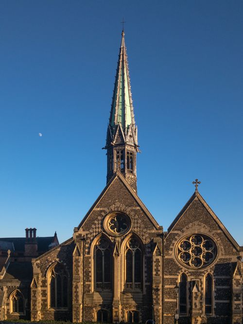 Free A stunning view of Harrow School Chapel with a clear blue sky and moon in the background. Stock Photo