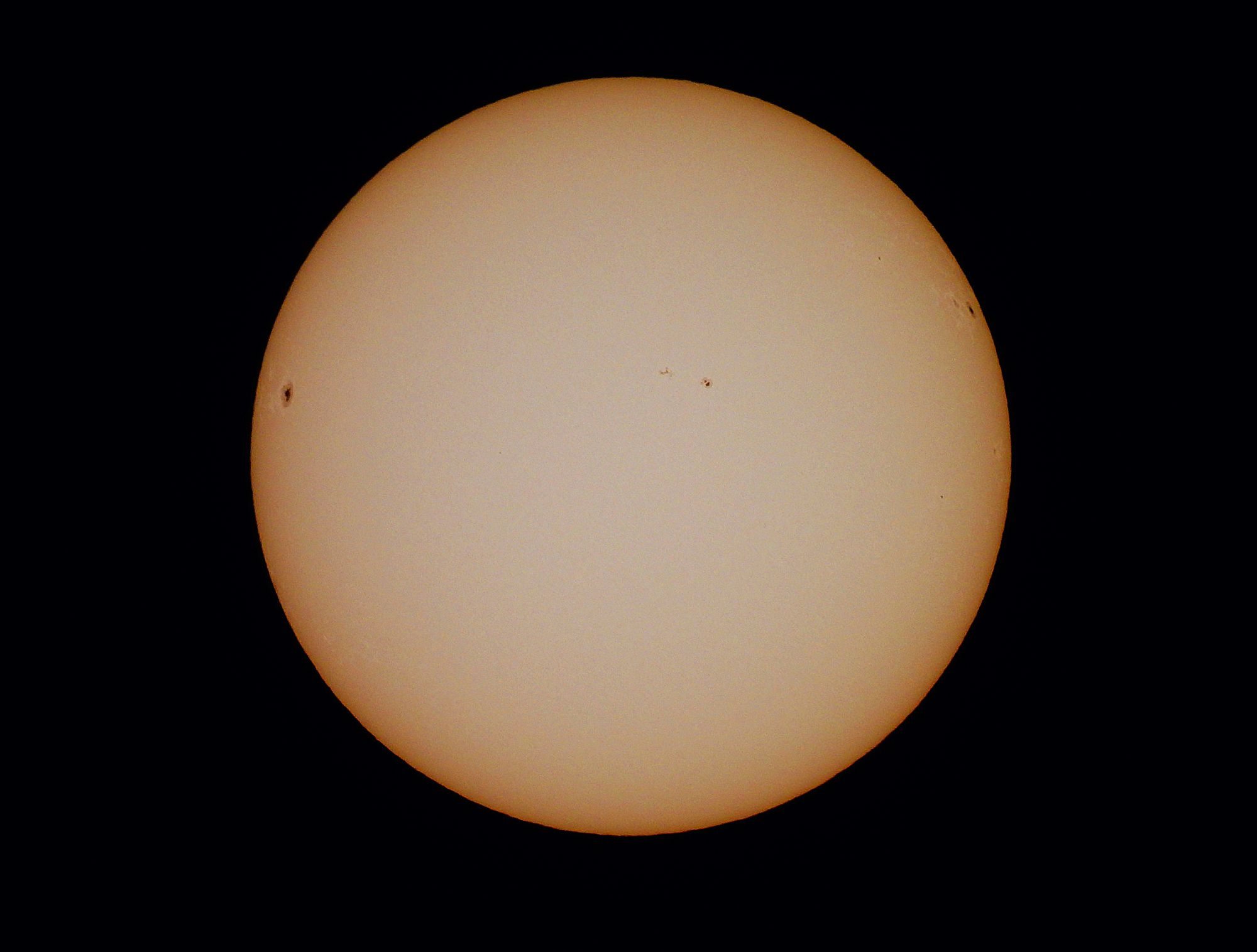 Detailed image of the sun showcasing visible sunspots against a dark background.