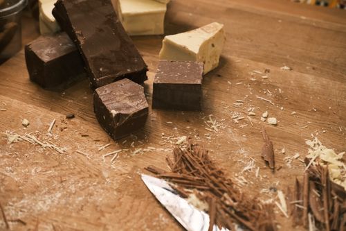 Free Close-up of various chocolate bars and shavings on a wooden board. Stock Photo