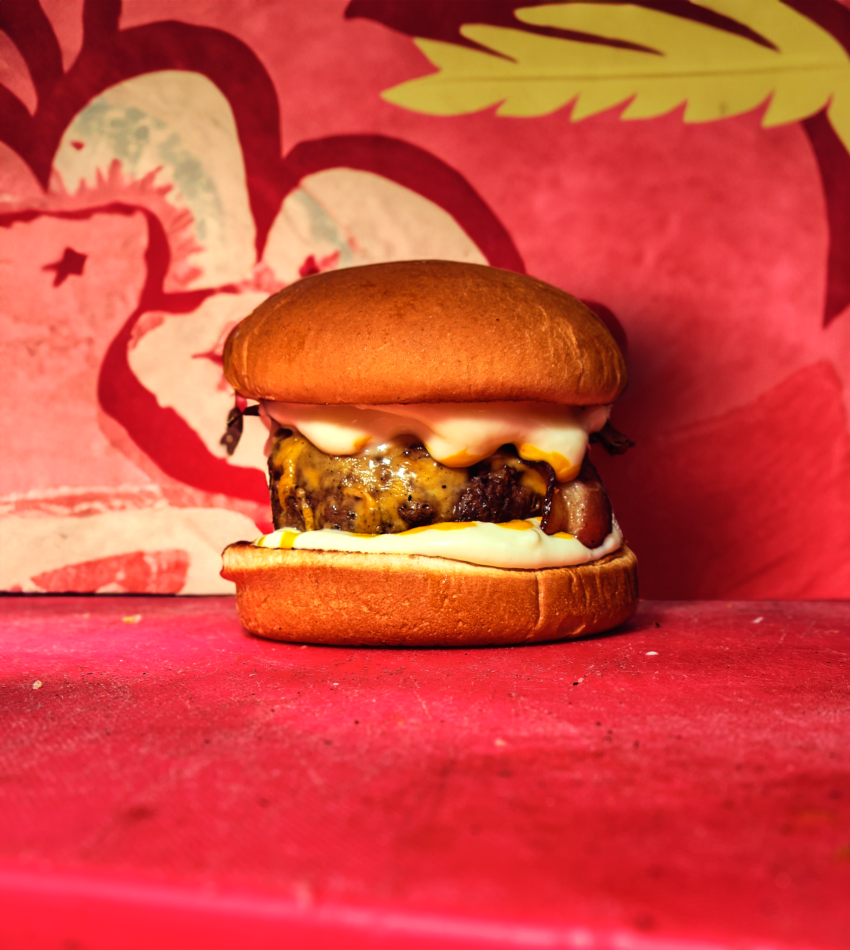 Close-up of a delicious cheeseburger with a vibrant artistic backdrop.