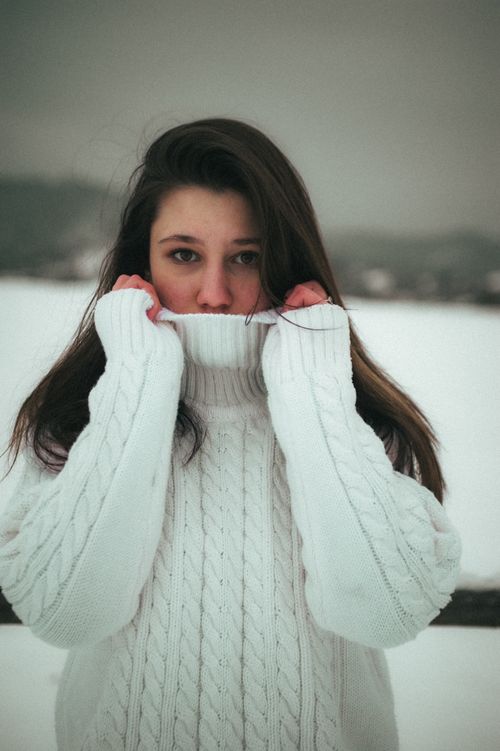 Free A moody winter portrait of a woman in a cozy sweater outdoors in Ukraine. Stock Photo