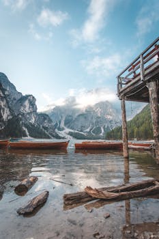 Idyllic mountains with boats at dawn, featuring serene lake and crisp morning air.