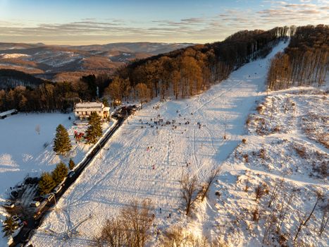 Aerial view of a snowy landscape in Daruvar with forest and hills.