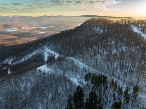 Free A beautiful aerial view of snowy hills and forests at sunset in Daruvar, Croatia. Stock Photo