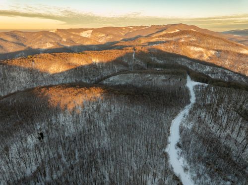 Free Captivating aerial view of snow-covered hills in Daruvar at sunset, showcasing serene winter beauty. Stock Photo