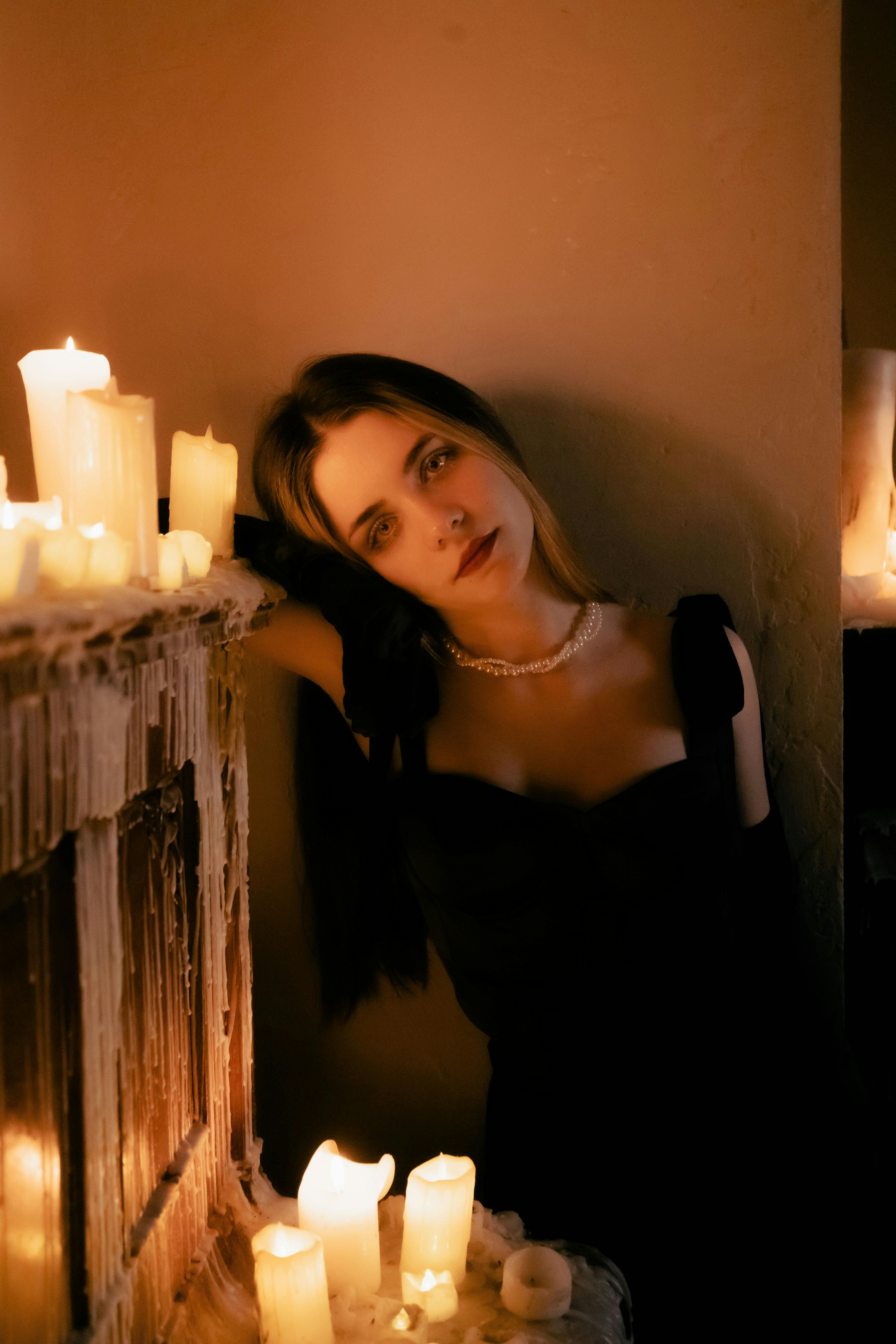 Moody portrait of a woman in candlelight, soft focus and intimate glow highlighting serene, surrendered expression