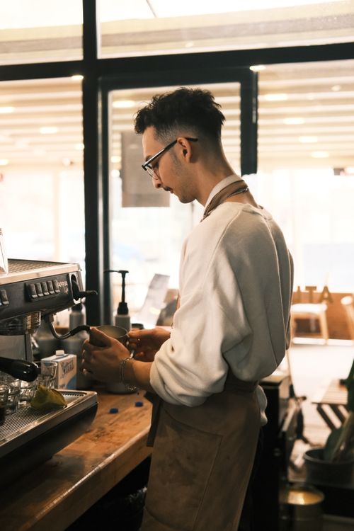 Free Professional barista preparing coffee with precision in a stylish café setting. Stock Photo