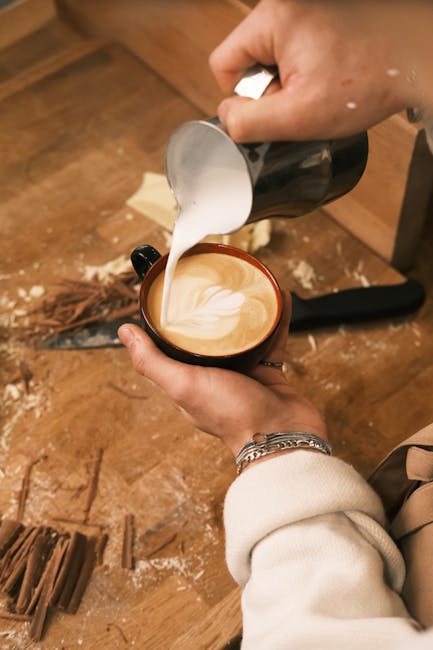 A barista preparing a modern interpretation of Kopi Gu Yu, with latte art and creative garnishes.