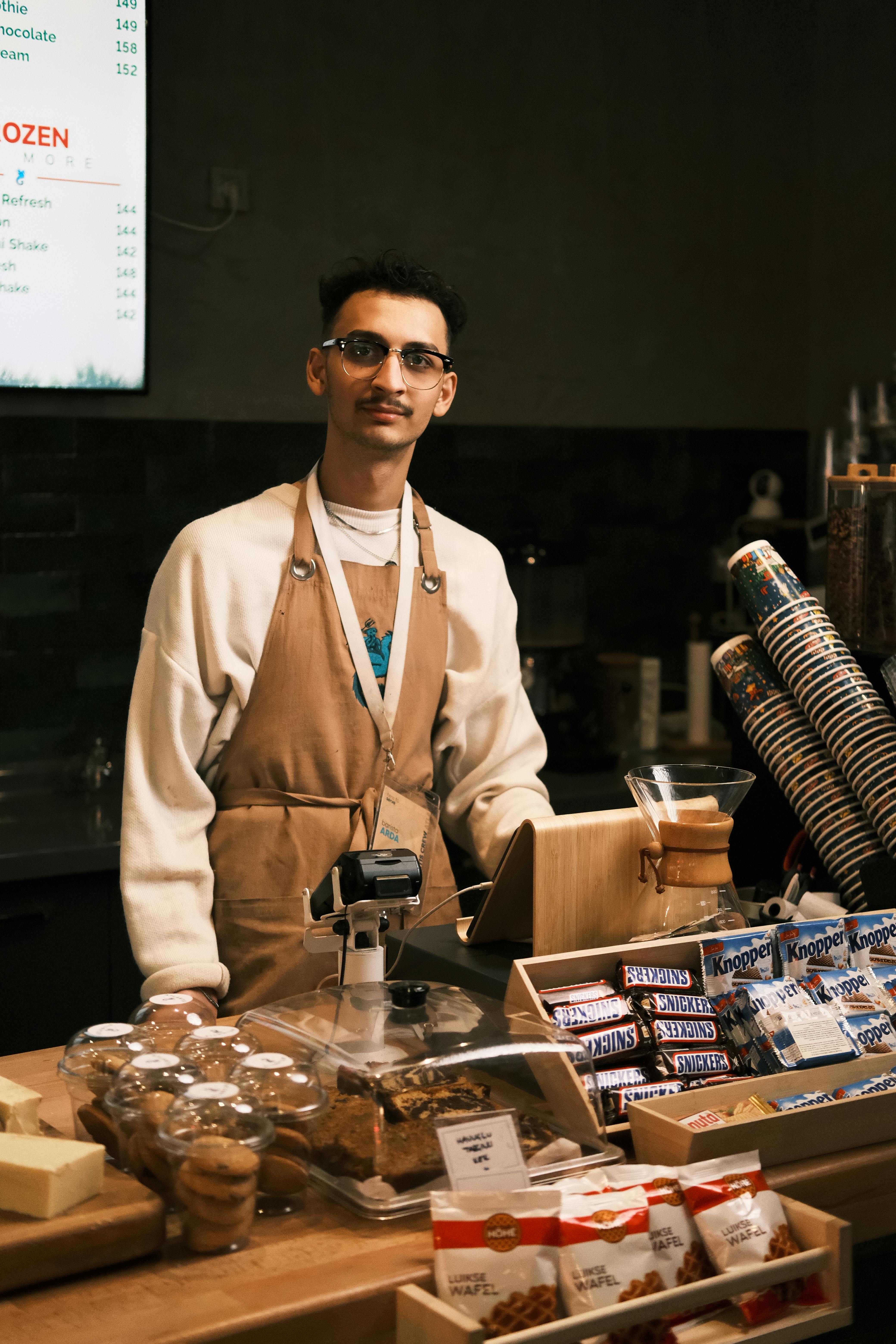 Barista in a cozy Turkish café ready to serve coffee and snacks indoors.