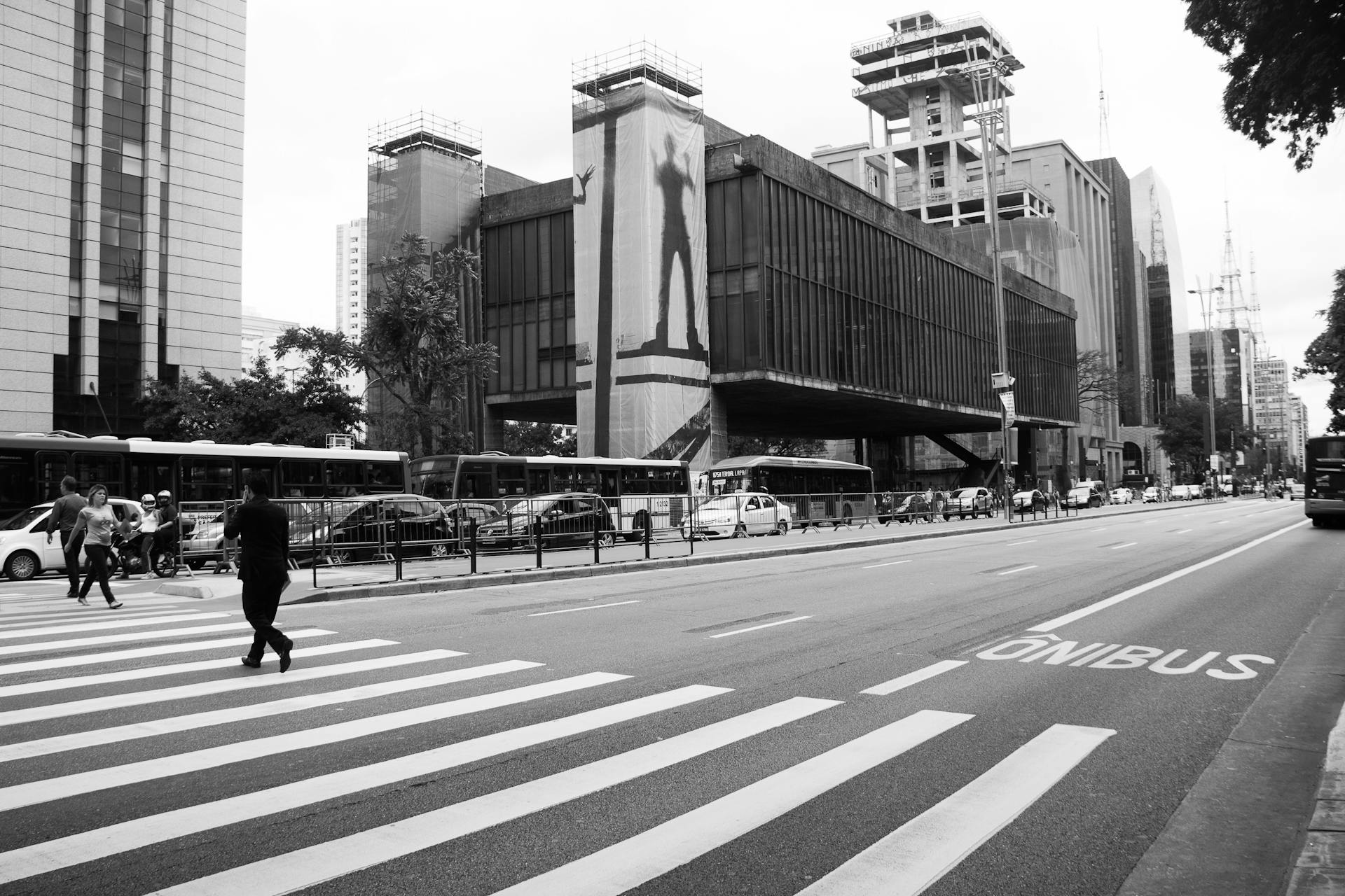 Black and white street view of MASP on Paulista Avenue, São Paulo.