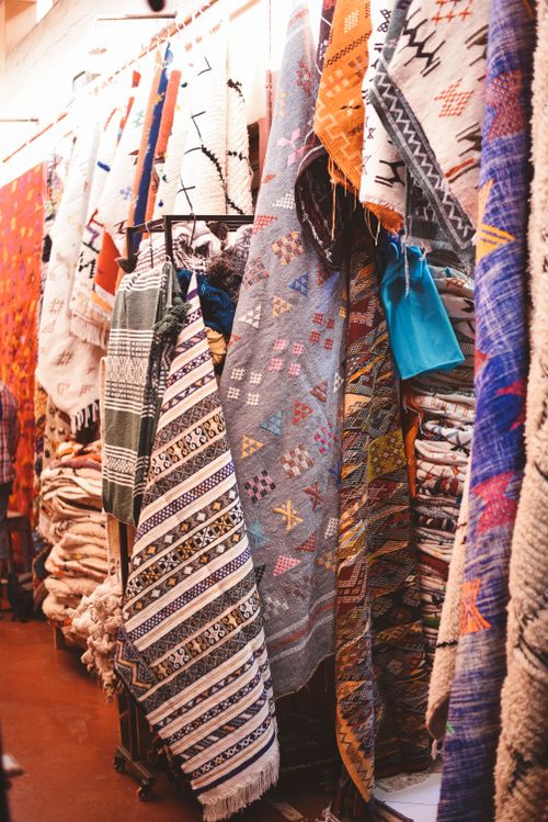Free Vibrant handcrafted rugs displayed in a market stall in Agadir, Morocco. Stock Photo