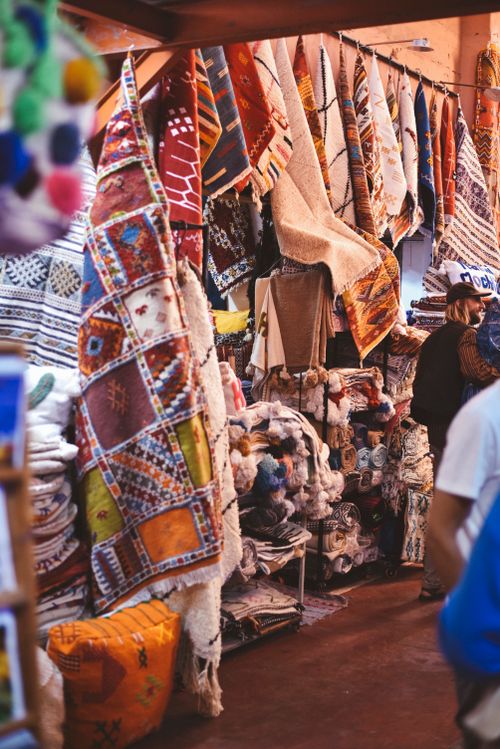 Free Vibrant scene of traditional rugs displayed at a Moroccan market, showcasing cultural craftsmanship. Stock Photo