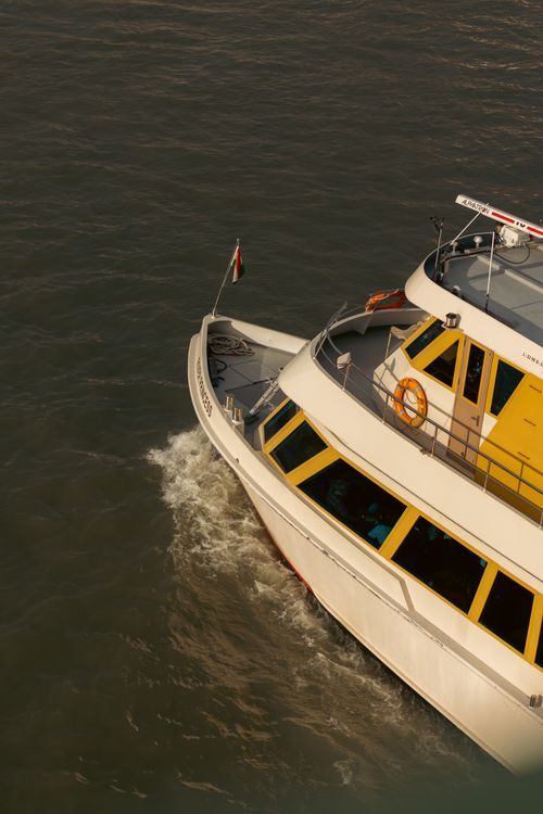 Free A ferry boat navigating a serene waterway, captured from an aerial perspective. Stock Photo
