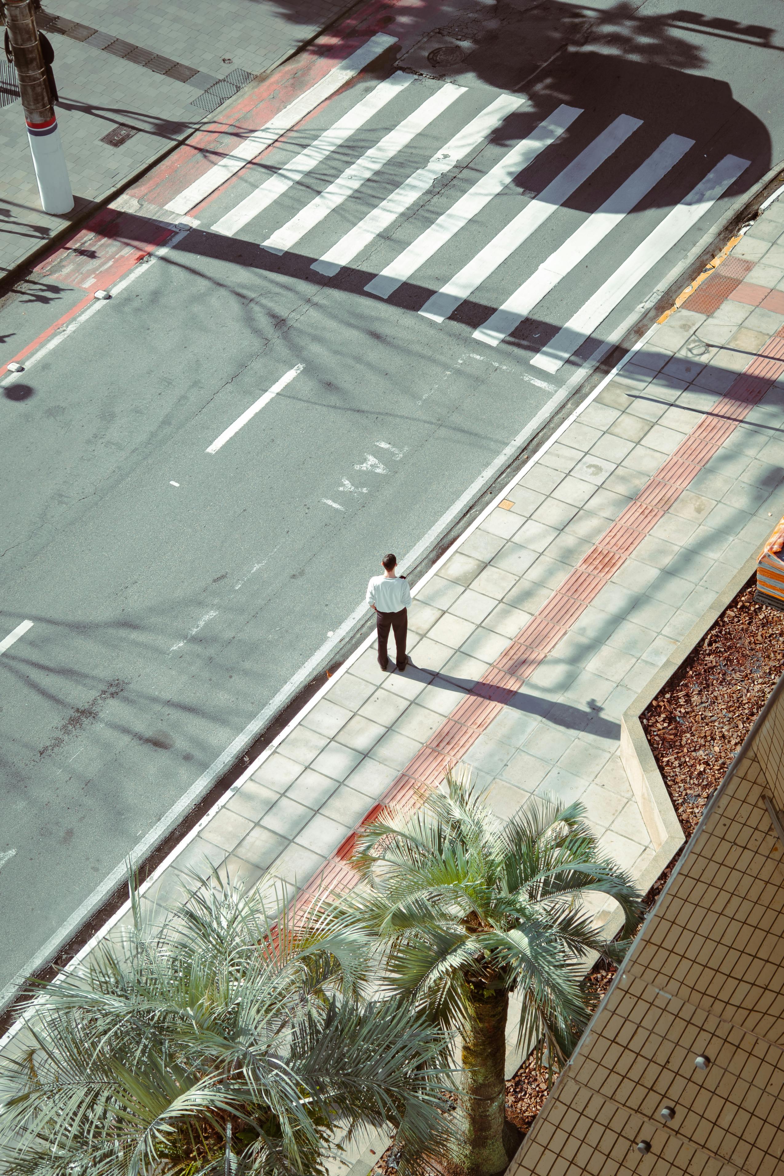 Aerial view of a solitary pedestrian at a crosswalk in Florianópolis.