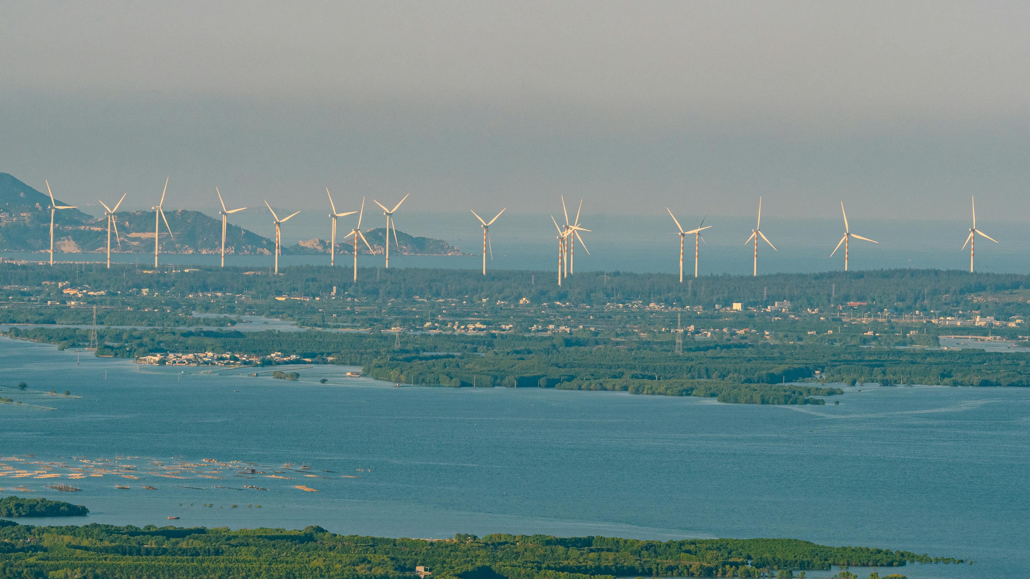 A scenic view of wind turbines along the coastal landscape in Quy Nhơn, Việt Nam.