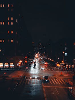A bustling city intersection at night with vibrant lights and moving traffic.