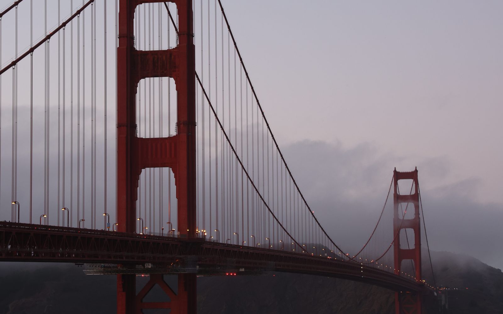 The Golden Gate Bridge at dusk under a foggy, hazy sky in San Francisco