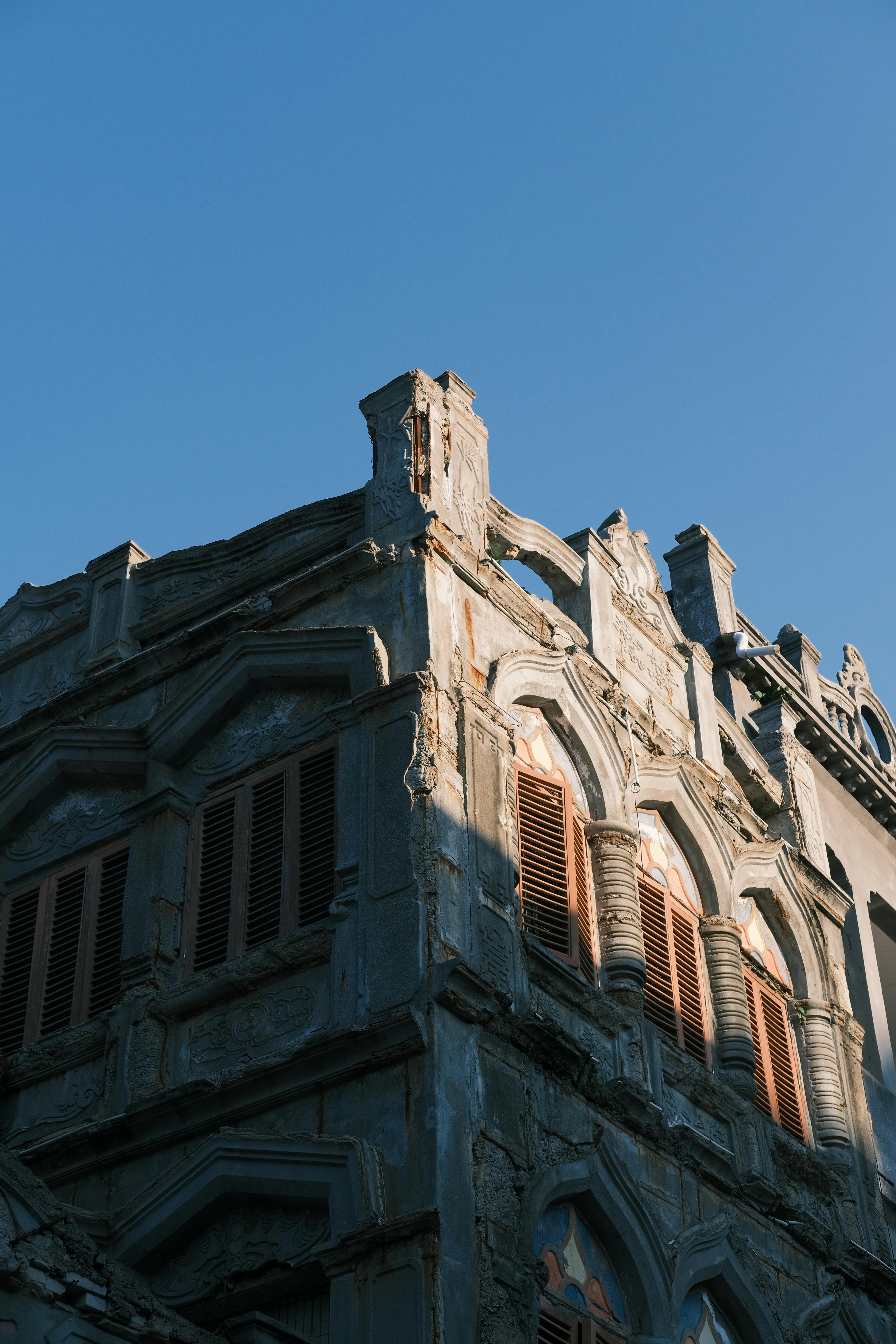 A historic building with detailed stone architecture against a clear blue sky.