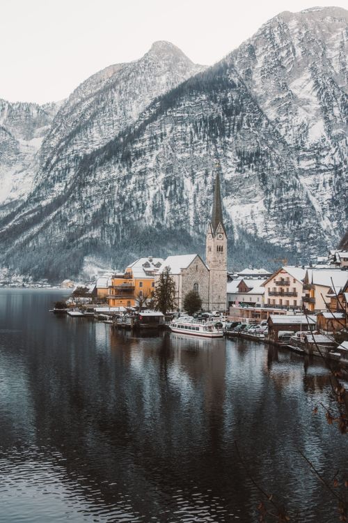 Free Serene winter landscape of Hallstatt village with snow-capped mountains and a tranquil lake. Stock Photo