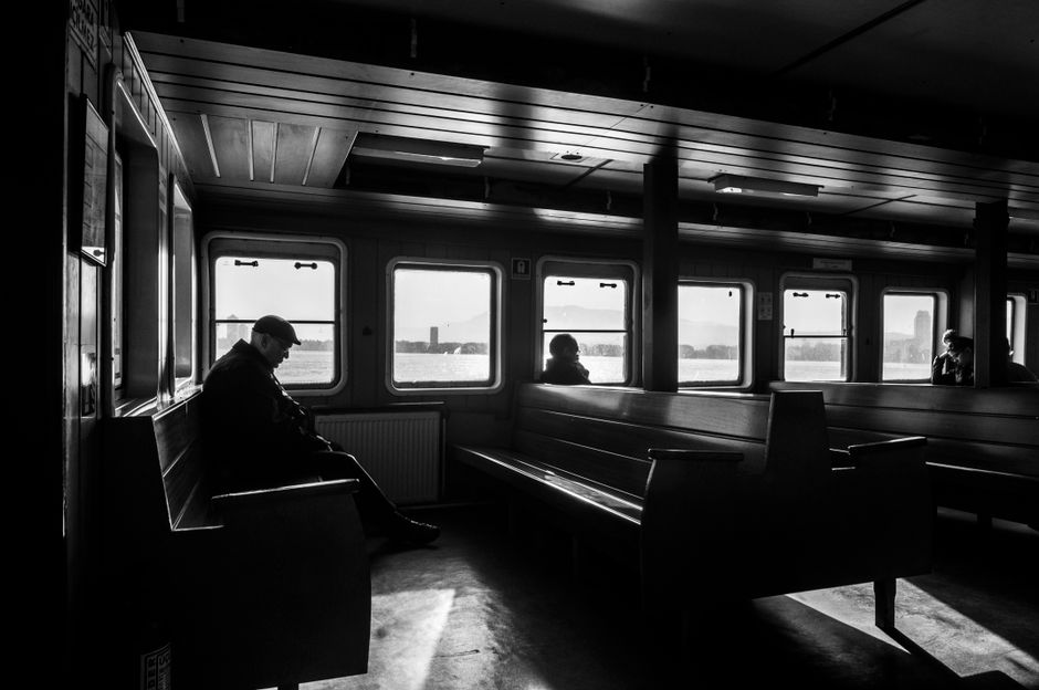 Monochrome scene of passengers on a ferry in İzmir, Türkiye, capturing a serene moment.