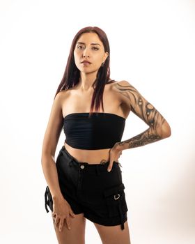 Bold studio portrait of a tattooed woman showcasing fashion and empowerment.