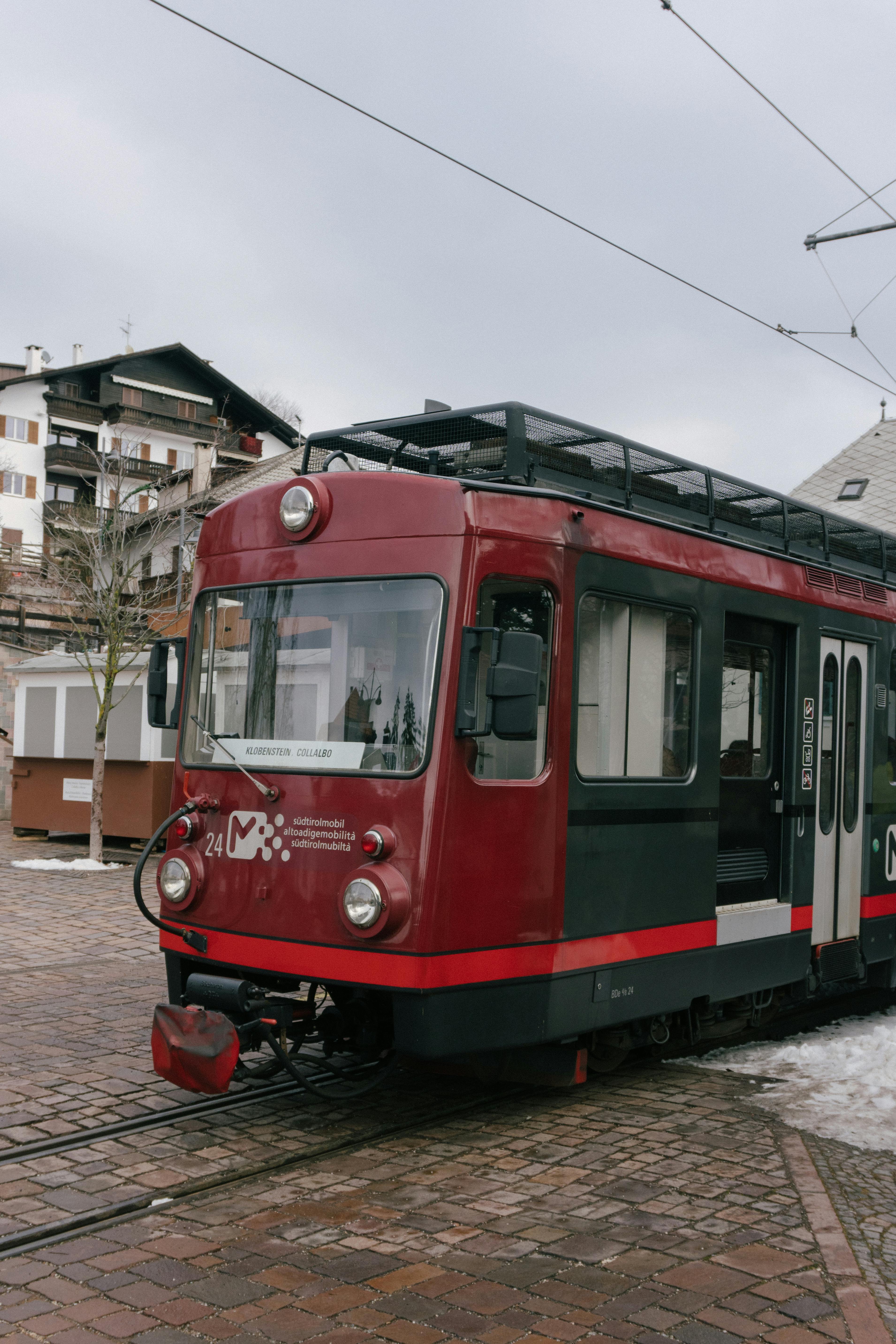 Free Red tram captured in Corvara, showing urban landscape of Italy. Stock Photo