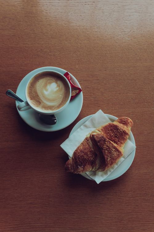 Free Tasty coffee and croissant on wooden table in Italian cafe, Collalbo, Italy. Stock Photo