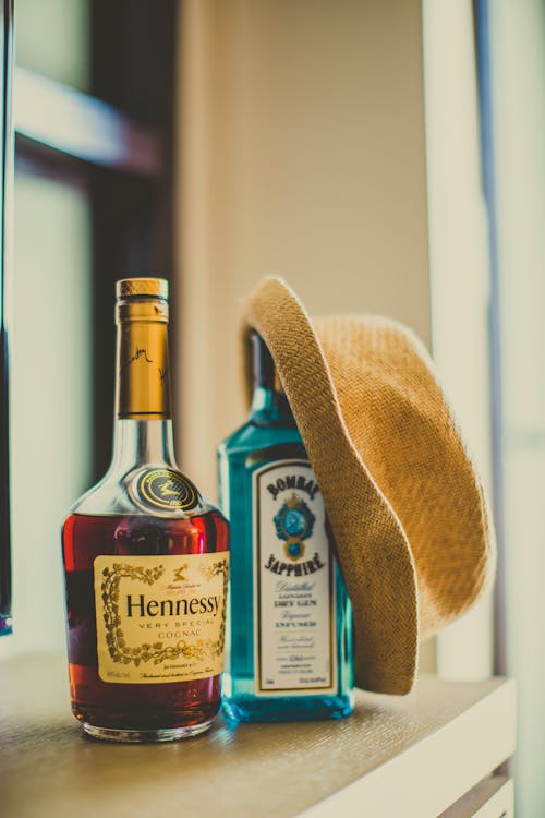 Free Two Assorted-brand Bottles with a Hat on One of the Bottle Stock Photo