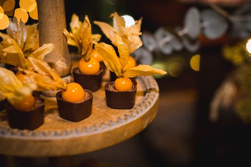 Free Gourmet chocolates with physalis on a rustic tray in warm festive lighting. Stock Photo
