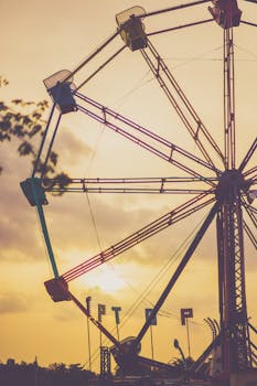 温暖的日落天空下，嘉年华上色彩缤纷的摩天轮轮廓清晰可见