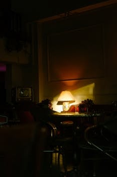 Ambient lighting in a vintage living room with a glowing table lamp and comfortable seating.