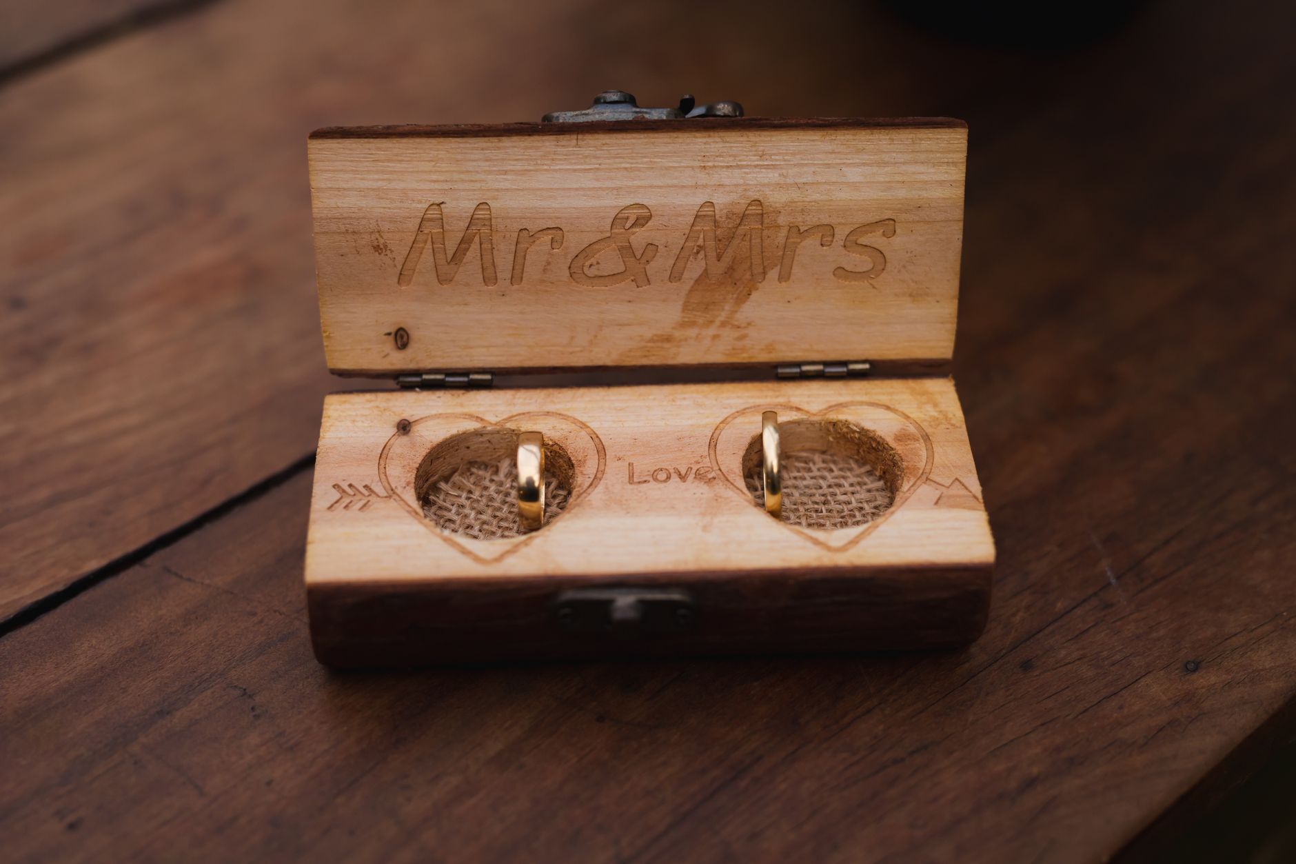 Elegant wedding rings displayed in a rustic wooden box engraved with Mr & Mrs.