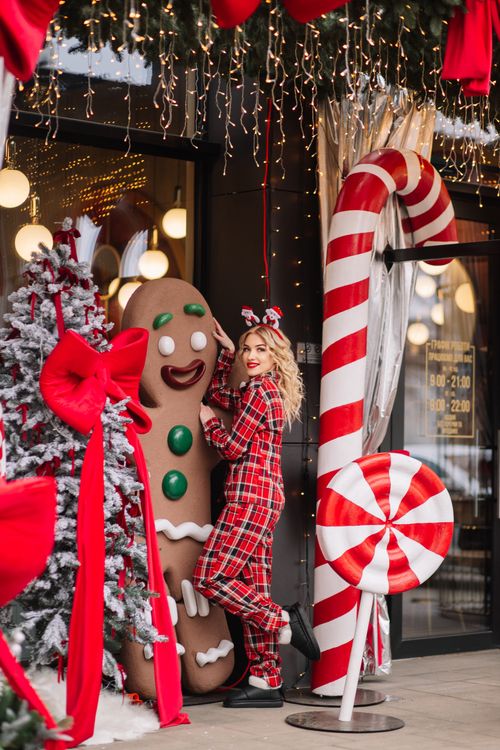 Free Woman in plaid pyjamas with gingerbread and candy cane decorations. Stock Photo